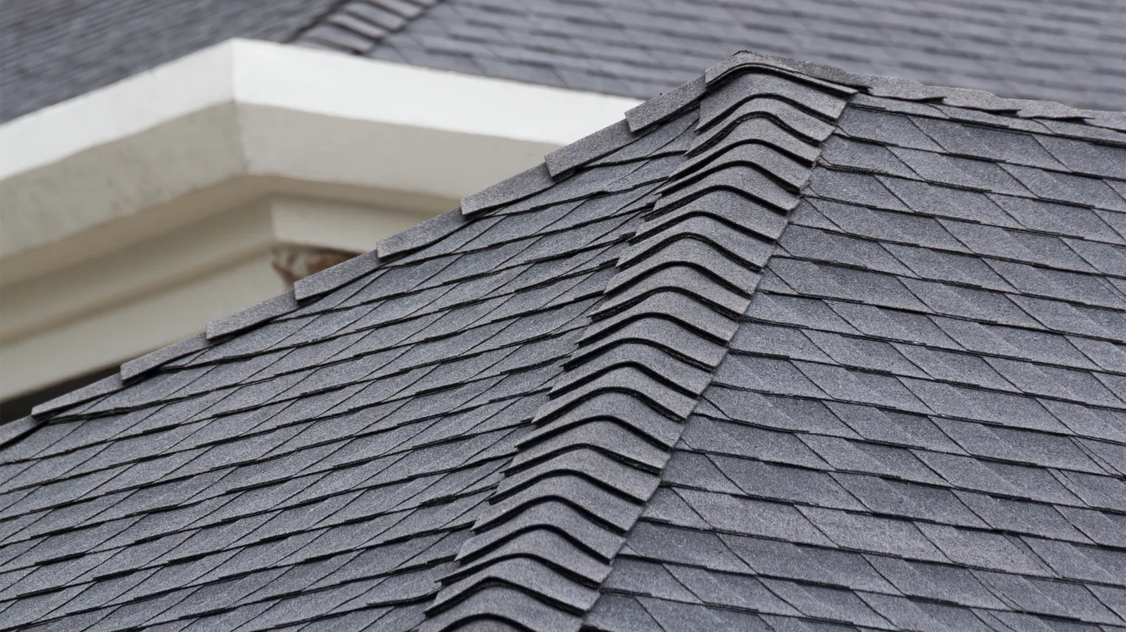 Ridge cap shingles along the hip of a gray shingle roof